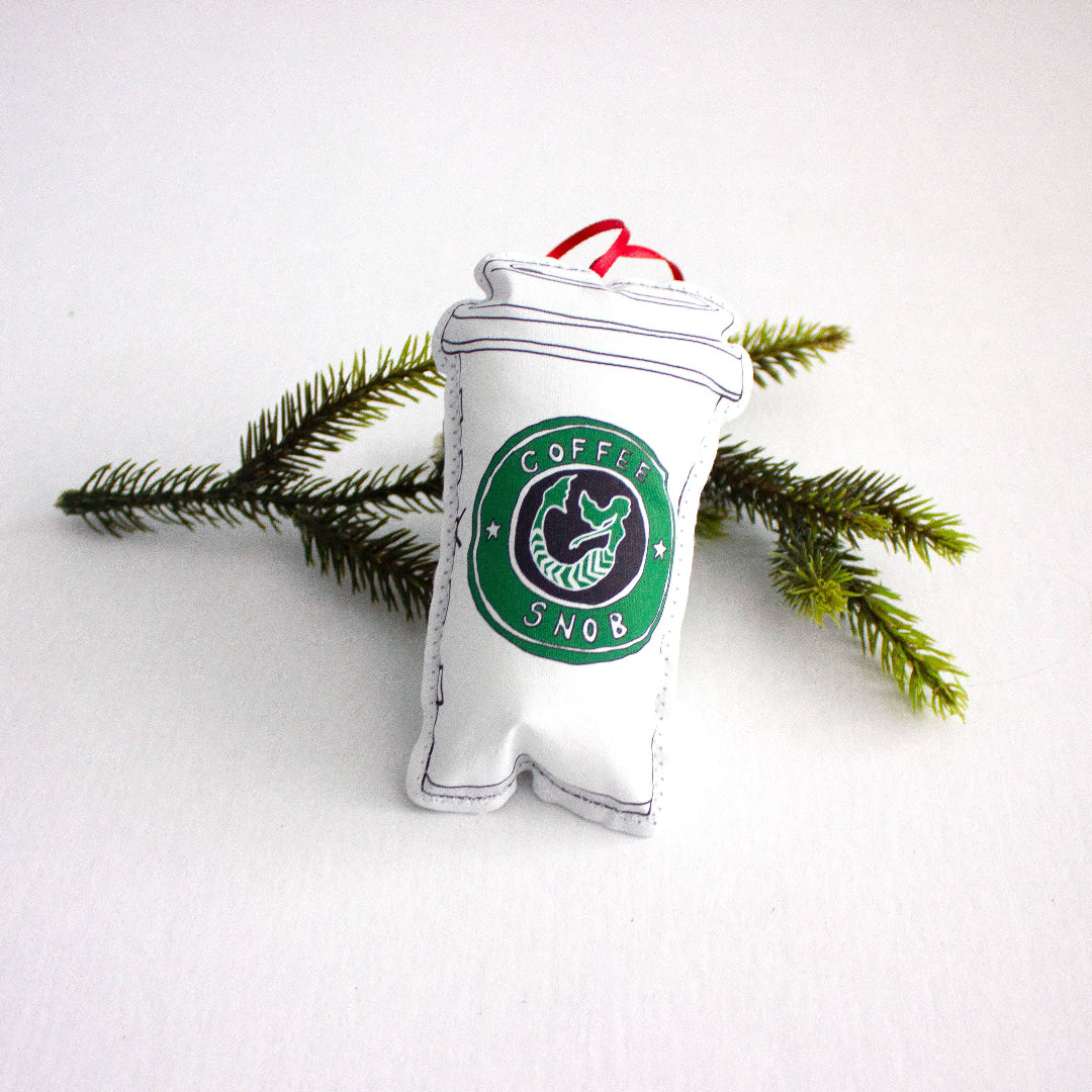 Decorative ornament shaped like a coffee cup with 'Coffee Snob' branding on a white background.