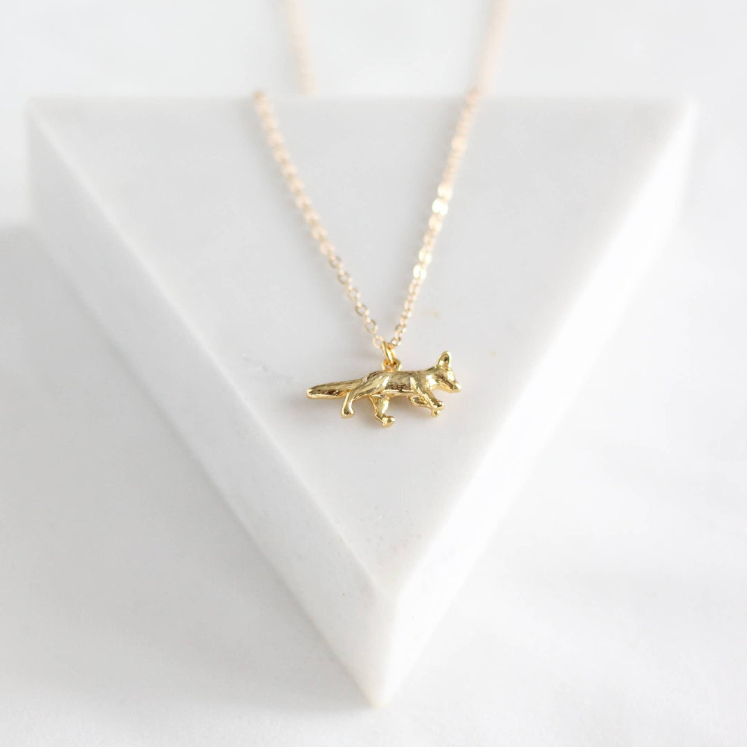 Gold necklace with a fox pendant on a white background