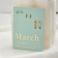 A set of three pairs of aquamarine earrings displayed on a light blue card. The set includes a pair of stud earrings, a pair of bar earrings with small aquamarine beads, and a pair of hoop earrings with dangling aquamarine stones. The card has the month "March" and the brand name "Foxy Originals."