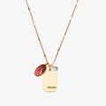 A gold necklace with an opal stone pendant. The pendant also has the word "HEALING" engraved on it. The necklace is displayed on a pink card with the month "October" and the brand name "Foxy Originals."