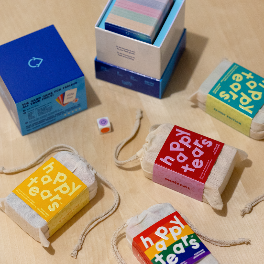 Happy Tears conversation cards, Ottawa. Inclusive card game for meaningful connections. Grey drawstring bag, multicoloured rainbow cards. Fun queer card game.