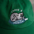 Green cap with a cat graphic and text 'I have a major problem' on a neutral background