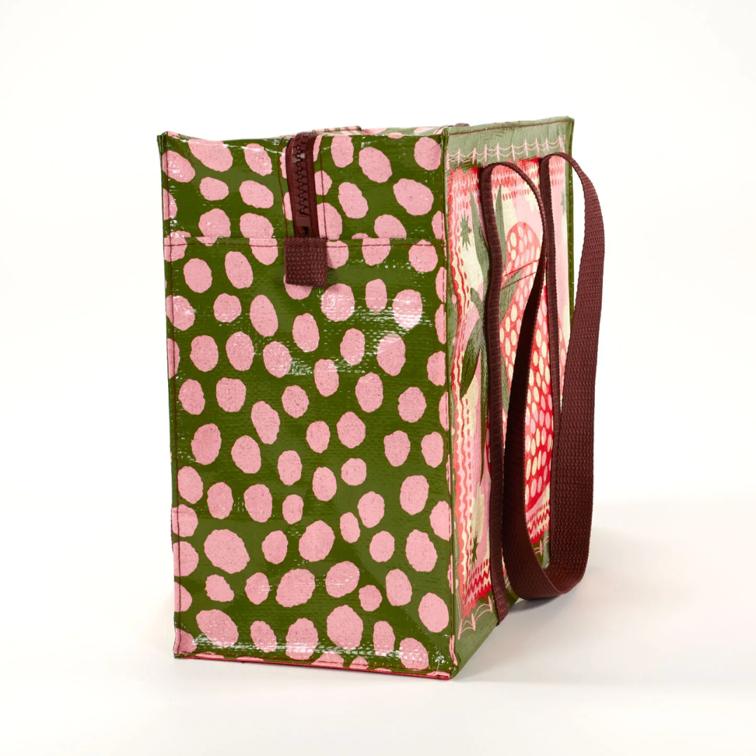 A reusable tote bag with a playful strawberry design. The bag is olive green with brown handles. It features a large pink strawberry in the center, surrounded by white clouds, stars, and pink polka dots. The strawberry has detailed leaves and seeds.