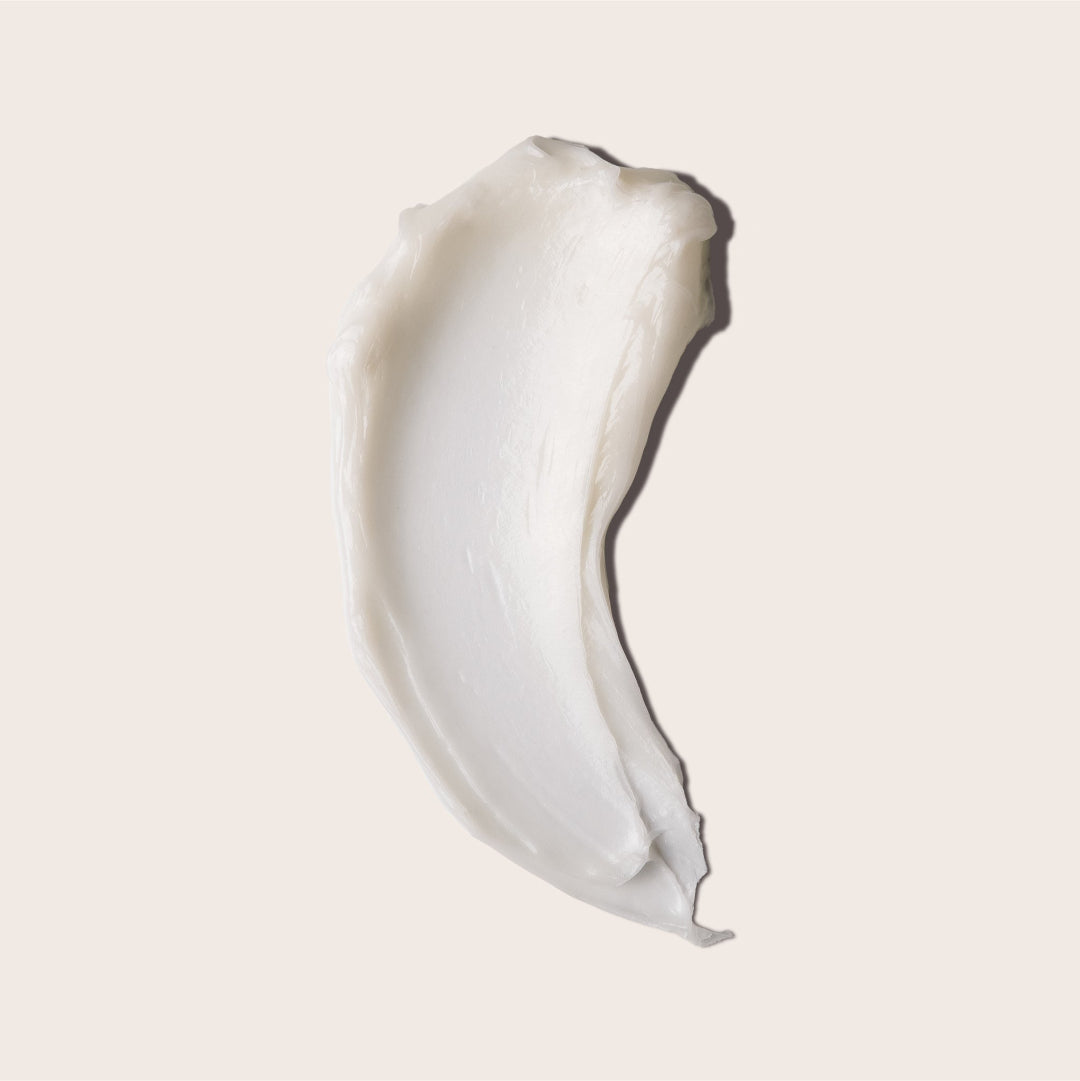 A small, open, silver metal tin of Everist's "The Fragrance-Free Conditioner Concentrate Mini," revealing a translucent, gel-like product inside. The tin's lid is propped against the base, and text on the side indicates it's dermatologist-developed and contains 20ml of product.